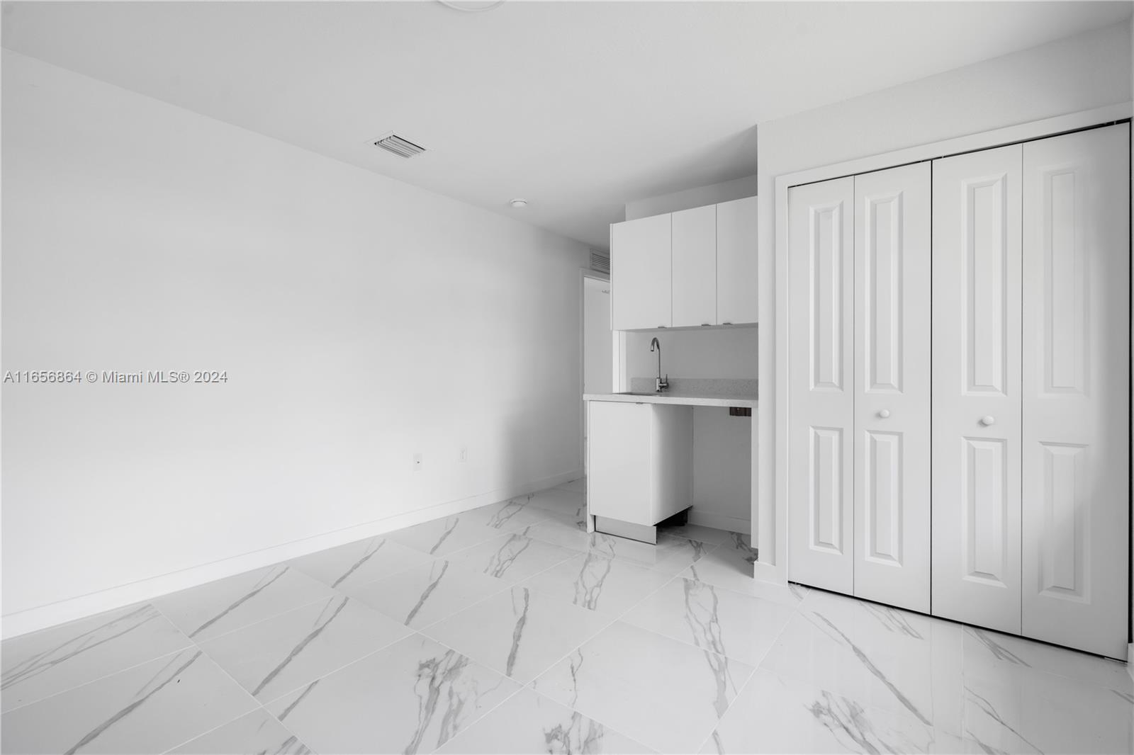 152 Northwest 18th Street Homestead, FL 33030 - Photo 14 of 28 a view of a kitchen with white cabinets and a refrigerator