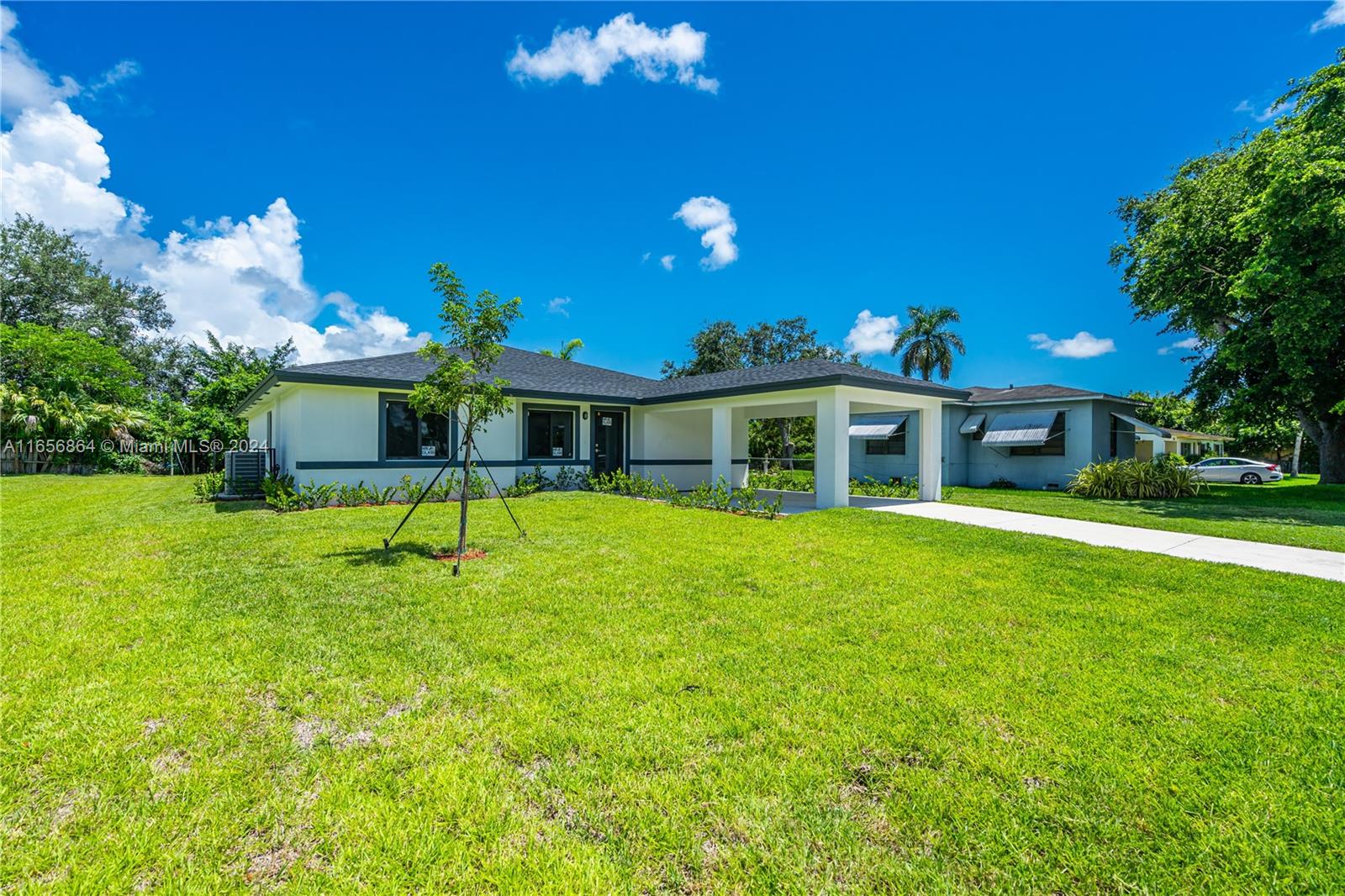 152 Northwest 18th Street Homestead, FL 33030 - Photo 2 of 28 a porch with a table and chairs under an umbrella