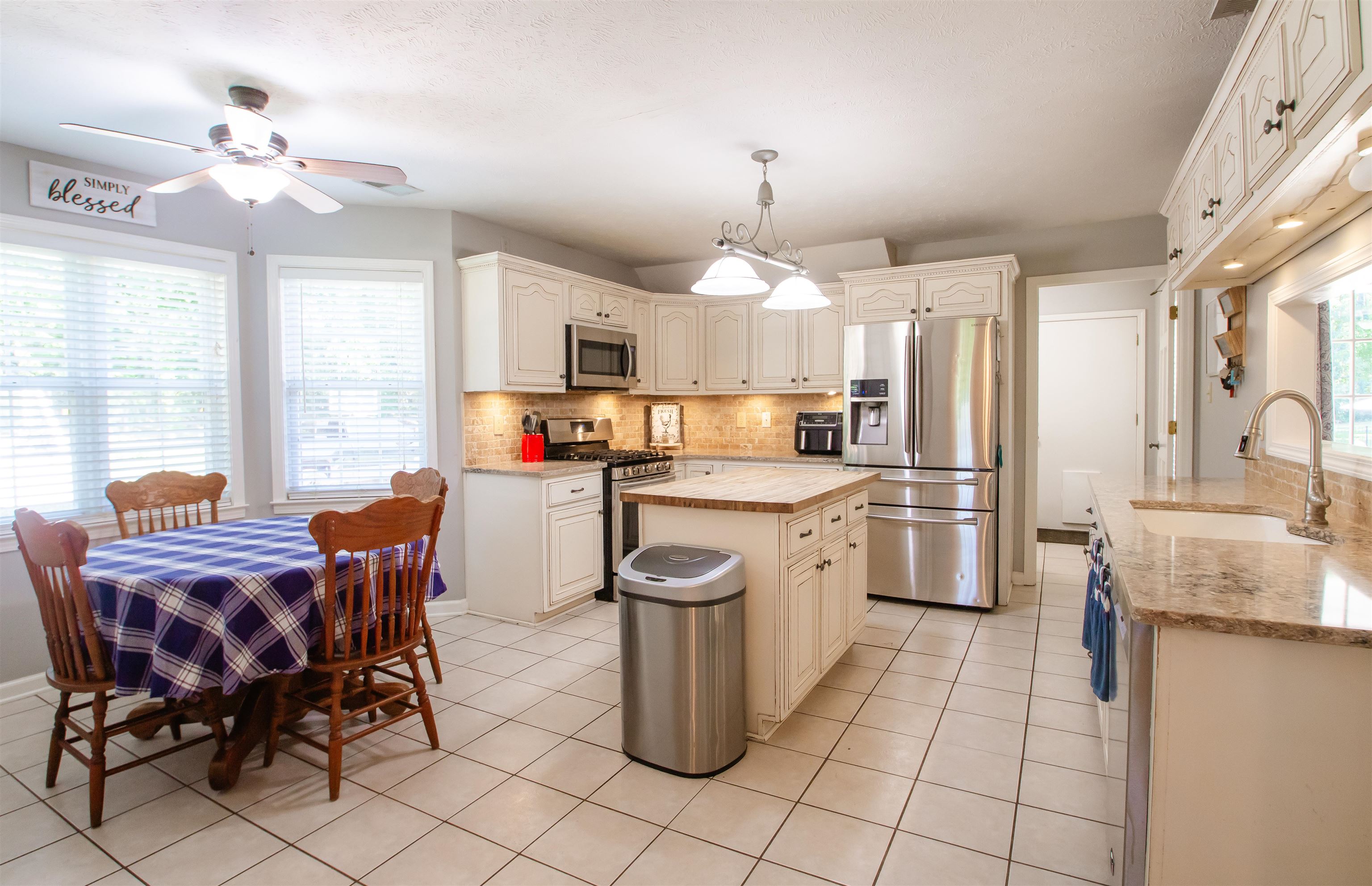 74 Huffman Road Brighton, TN 38011 - Photo 17 of 28 Kitchen featuring appliances with stainless steel finishes, sink, backsplash, light tile patterned floors, and a kitchen island