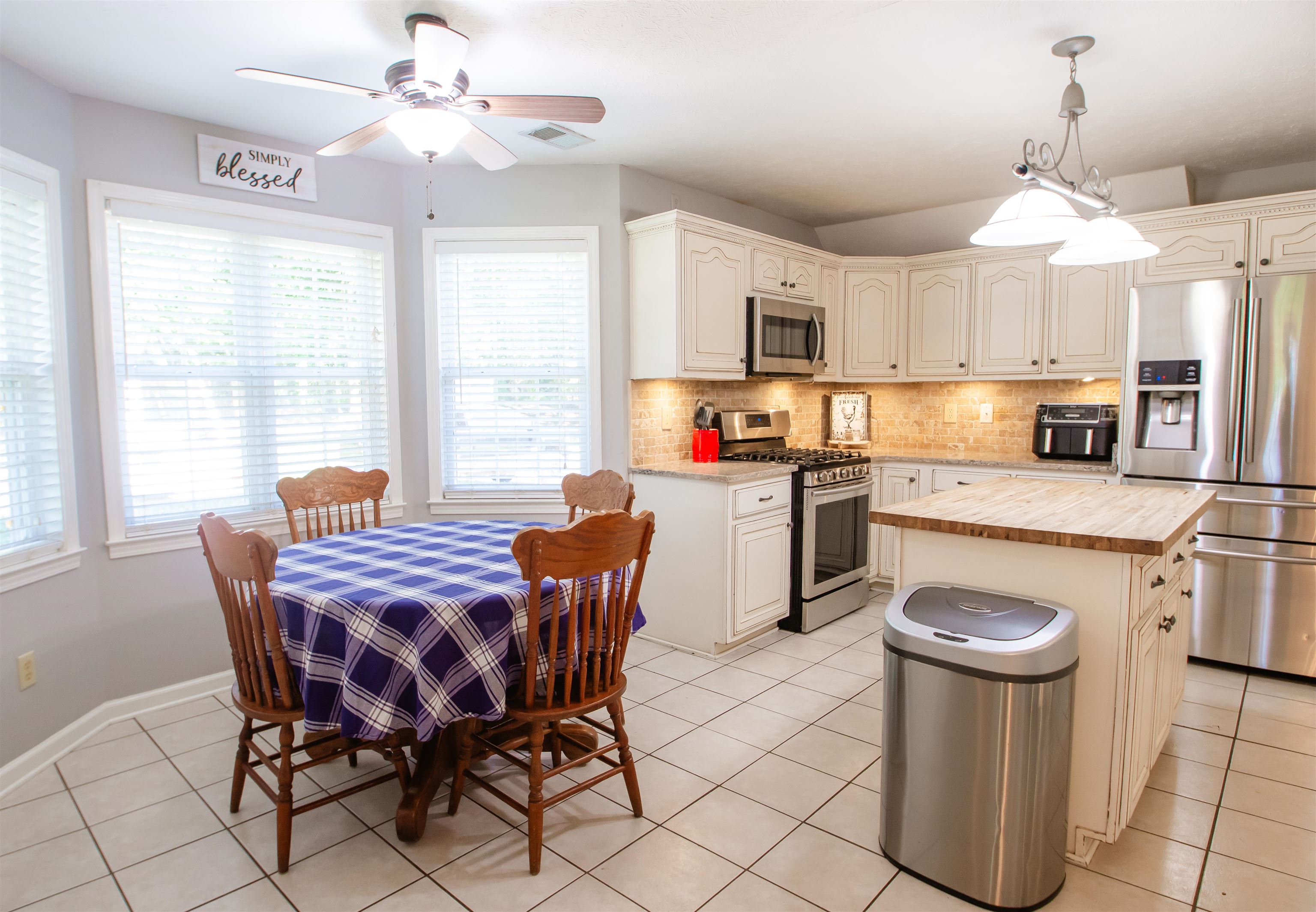 74 Huffman Road Brighton, TN 38011 - Photo 21 of 28 Kitchen featuring tasteful backsplash, butcher block counters, a center island, appliances with stainless steel finishes, and light tile patterned floors