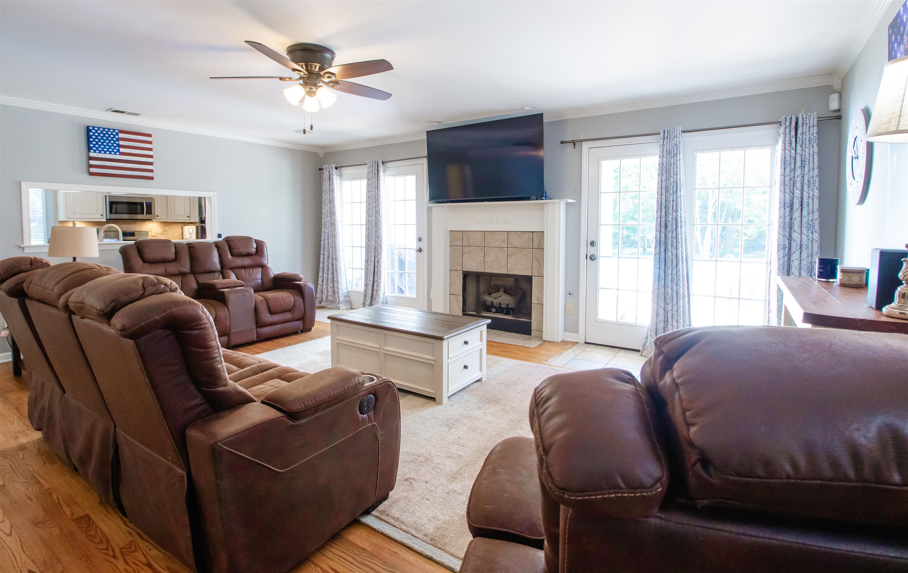 74 Huffman Road Brighton, TN 38011 - Photo 8 of 28 Living room featuring light hardwood / wood-style floors, a tiled fireplace, ceiling fan, and crown molding