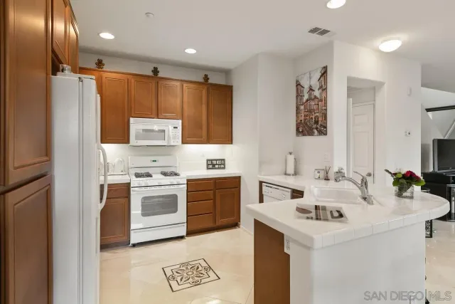 a kitchen with a refrigerator a stove and wooden cabinets