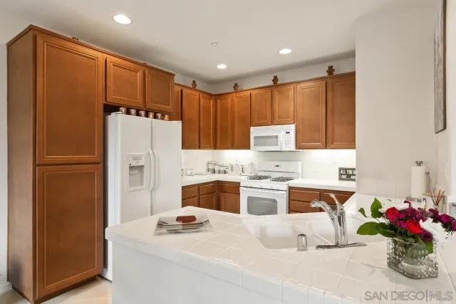a kitchen with a sink stove and chairs