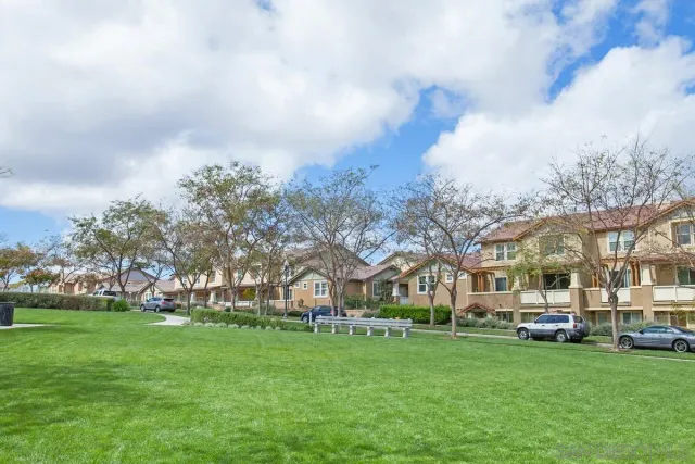 a view of a big yard with swimming pool and green space