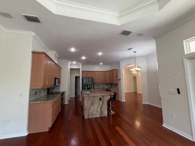 a kitchen with a refrigerator a sink and chairs
