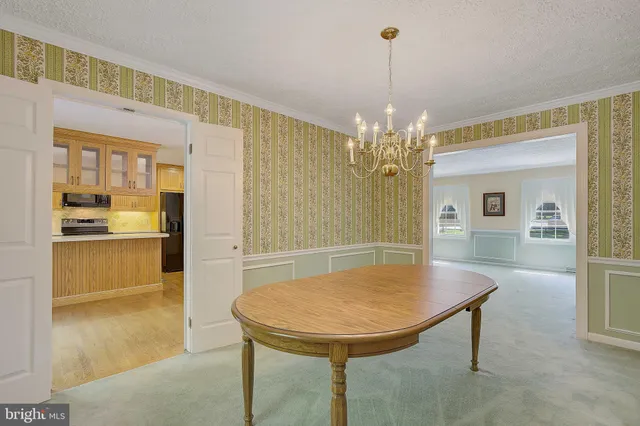a view of a dining room with furniture and chandelier