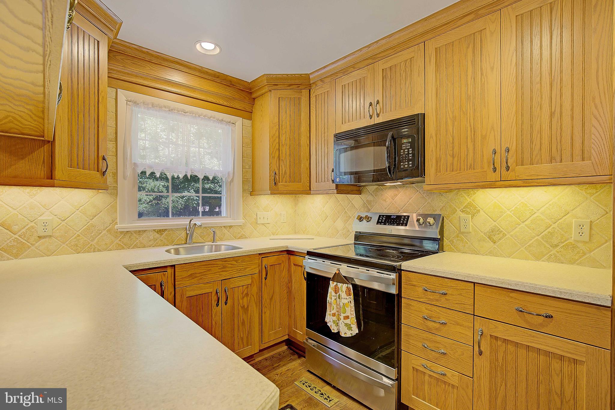 1750 Timber Court Huntingtown, MD 20639 - Photo 25 of 57 a kitchen with stainless steel appliances granite countertop a sink a stove and a microwave oven