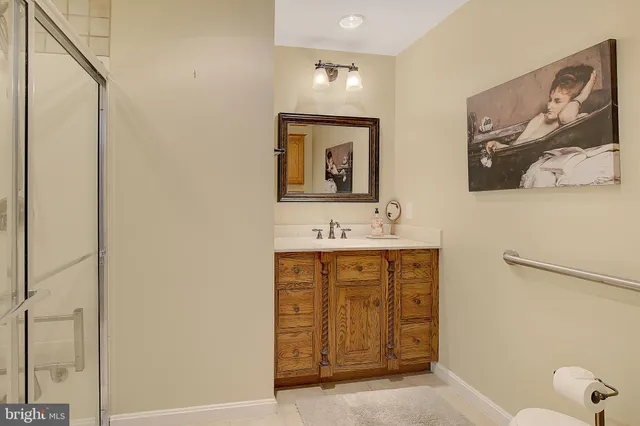 a bathroom with a granite countertop sink a toilet and shower