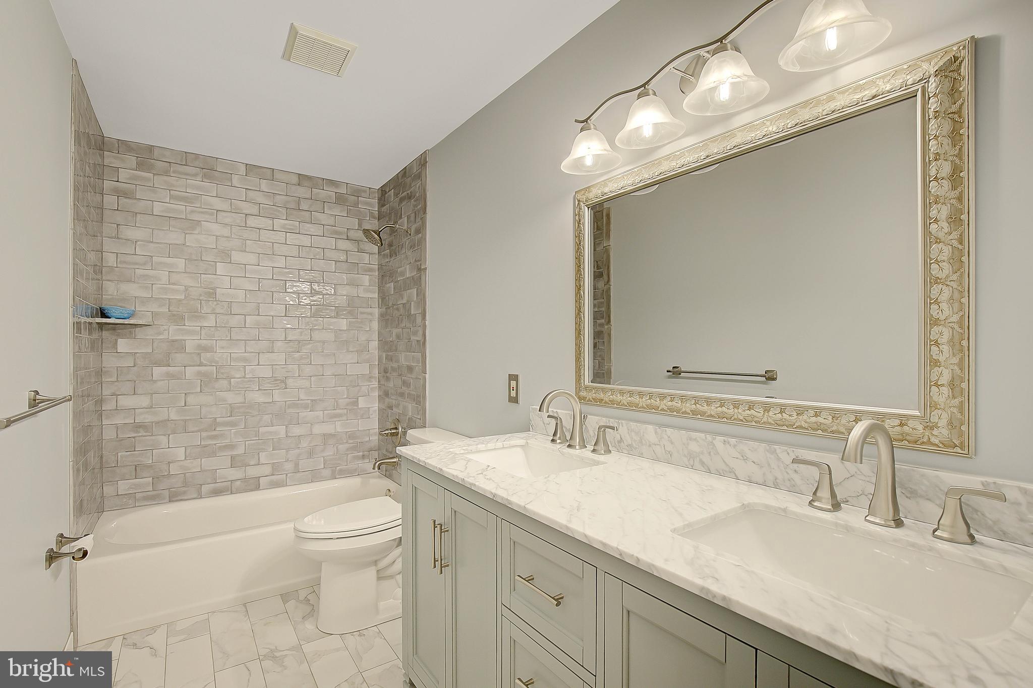 1750 Timber Court Huntingtown, MD 20639 - Photo 46 of 57 a bathroom with a granite countertop sink a toilet and shower