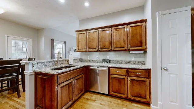 a kitchen with stainless steel appliances granite countertop wooden cabinets and a sink