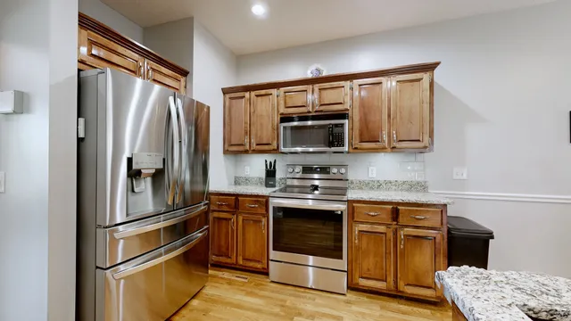 a kitchen with stainless steel appliances granite countertop a refrigerator stove and sink