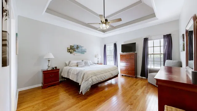 a bedroom with a large bed a chandelier and window