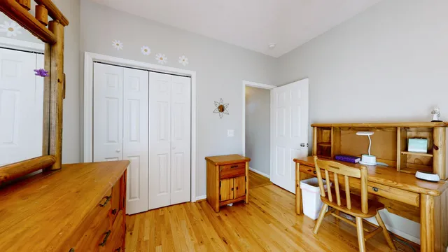 a view of a bedroom with wooden floor and furniture