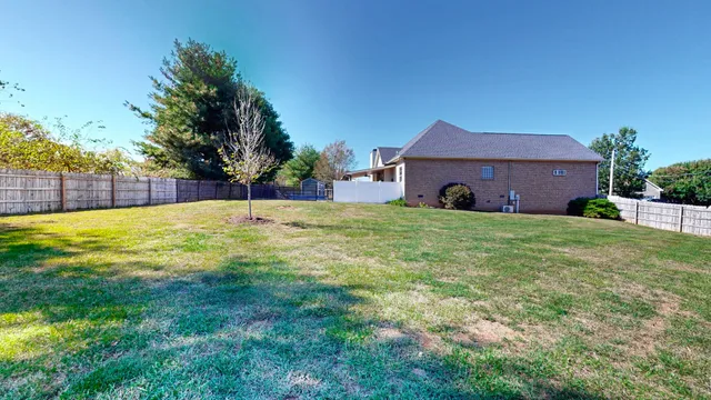 a large house with a big yard and large trees