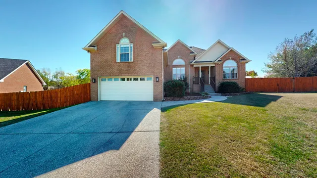 a front view of house with yard and trees in the background