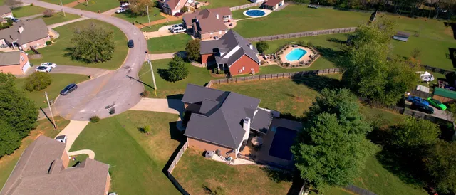 an aerial view of a house with outdoor space and a lake view