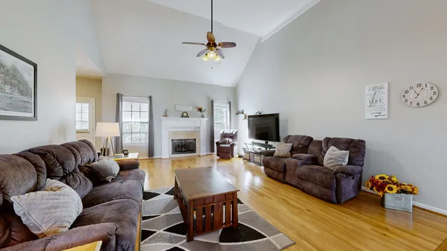 a living room with furniture a fireplace and a flat screen tv