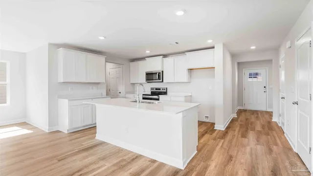 a kitchen with a sink a refrigerator and cabinets