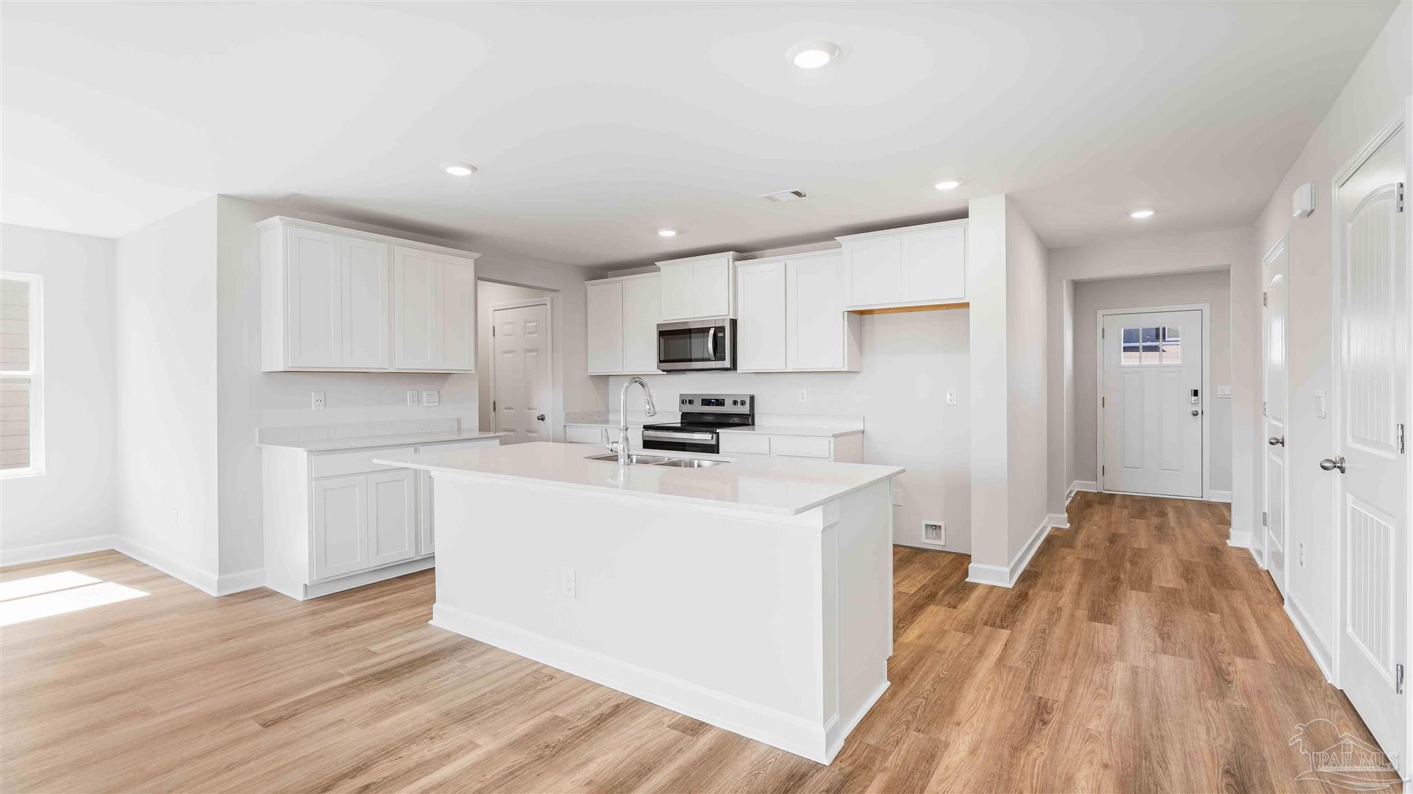8670 Bluebell Street Milton, FL 32583 - Photo 3 of 10 a kitchen with a sink a refrigerator and cabinets