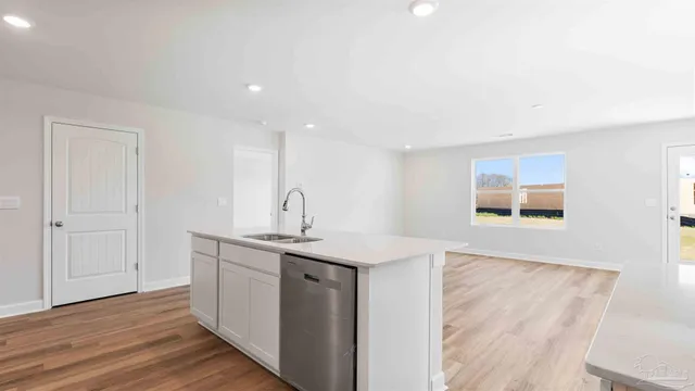 a kitchen with a sink cabinets and wooden floor