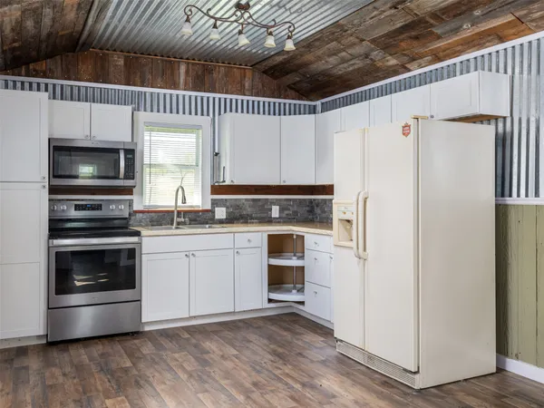a kitchen with a refrigerator stove and white cabinets