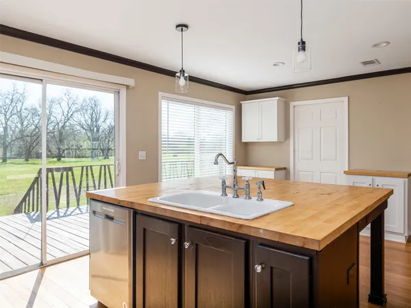 a kitchen with a sink a large window appliances and cabinets