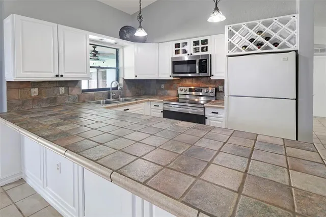 a living room with stainless steel appliances furniture and a flat screen tv
