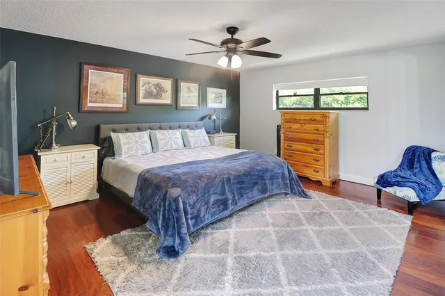 a bedroom with a bed a flat screen tv and a chandelier