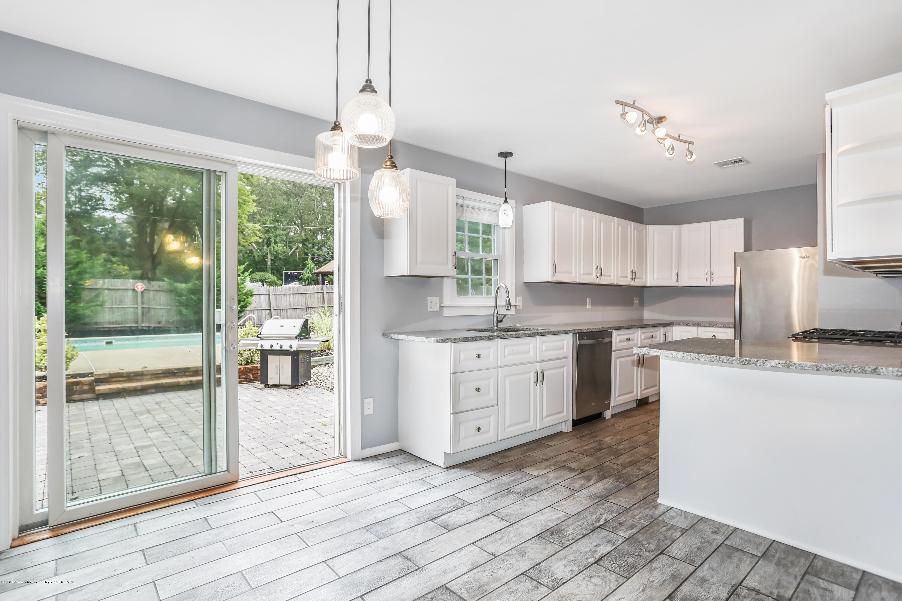 1822 Carmerville Road Wall, NJ 07719 - Photo 14 of 25 a kitchen with kitchen island a large counter top space a sink stainless steel appliances and cabinets