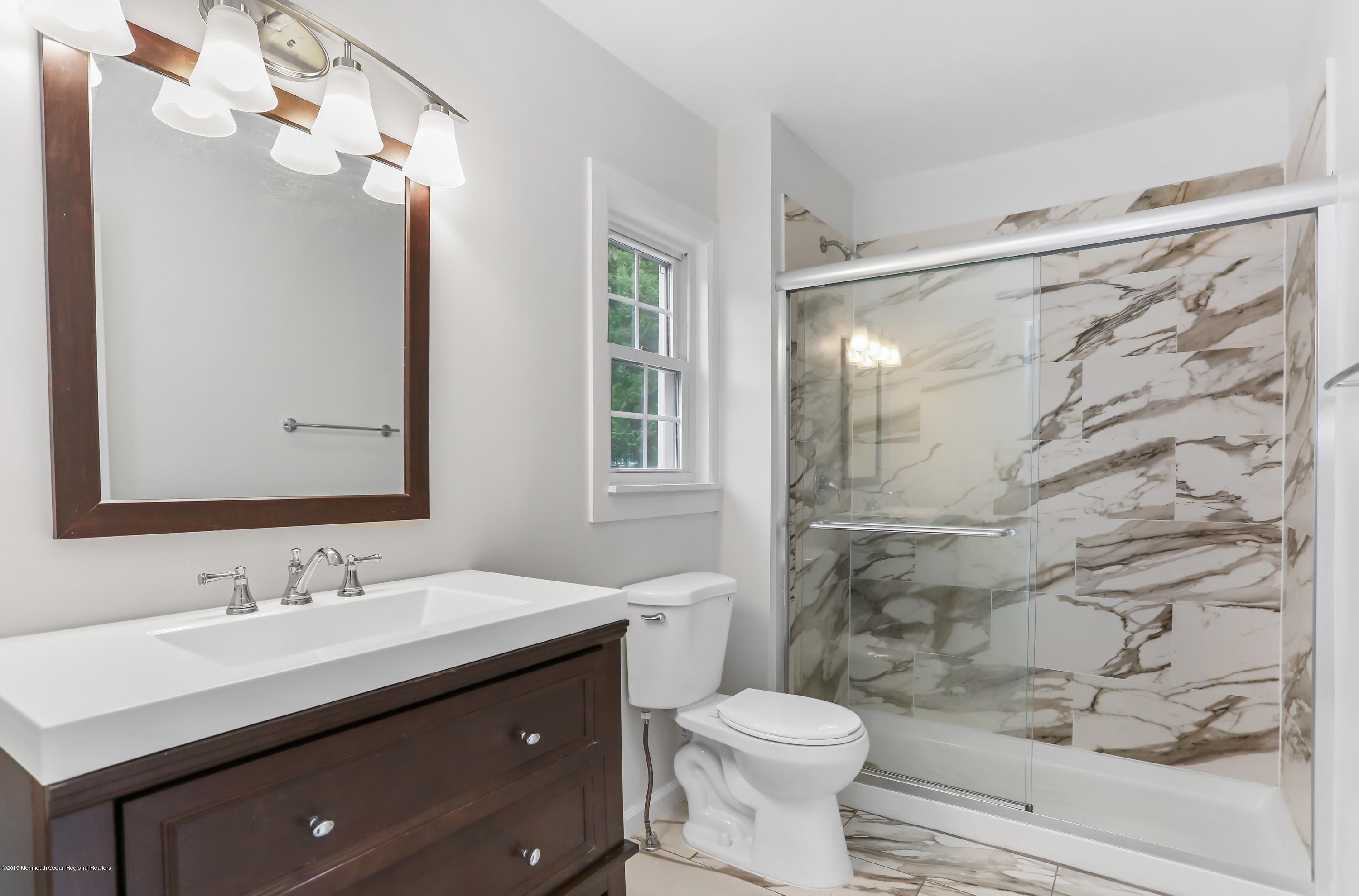 1822 Carmerville Road Wall, NJ 07719 - Photo 17 of 25 a bathroom with a granite countertop sink toilet a mirror a vanity and shower