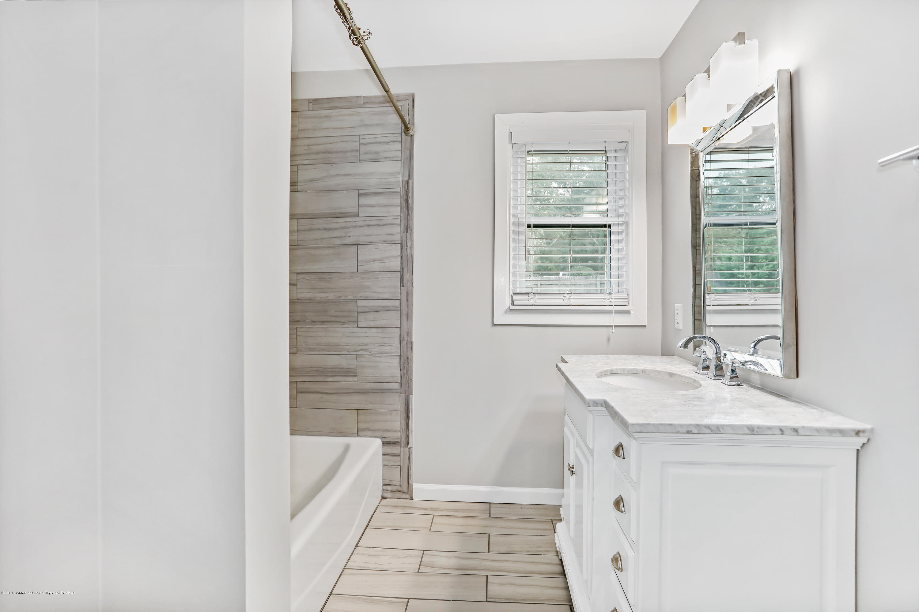 1822 Carmerville Road Wall, NJ 07719 - Photo 18 of 25 a bathroom with a granite countertop sink a bathtub and next to a window
