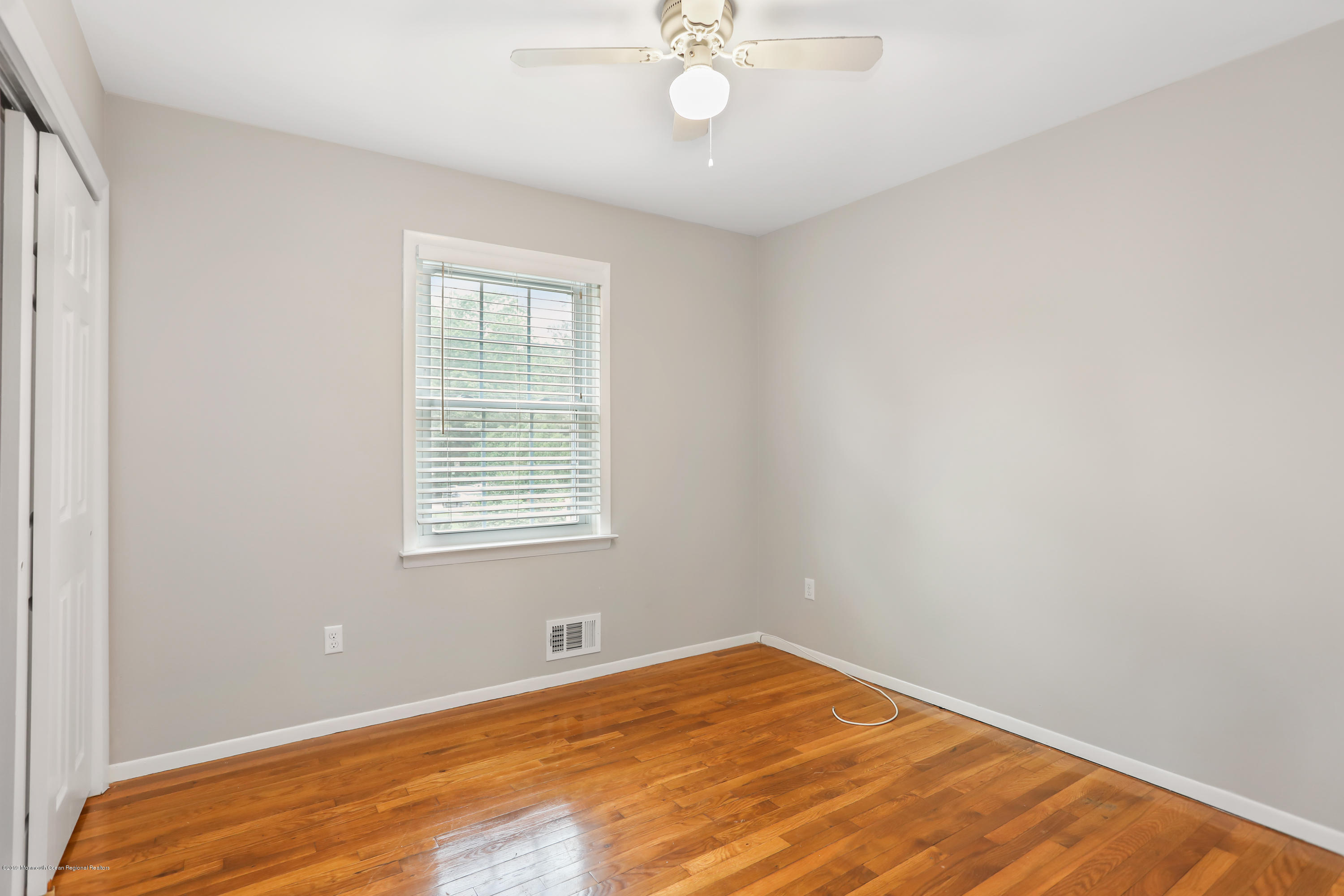 1822 Carmerville Road Wall, NJ 07719 - Photo 19 of 25 a view of a room with wooden floor and chandelier fan