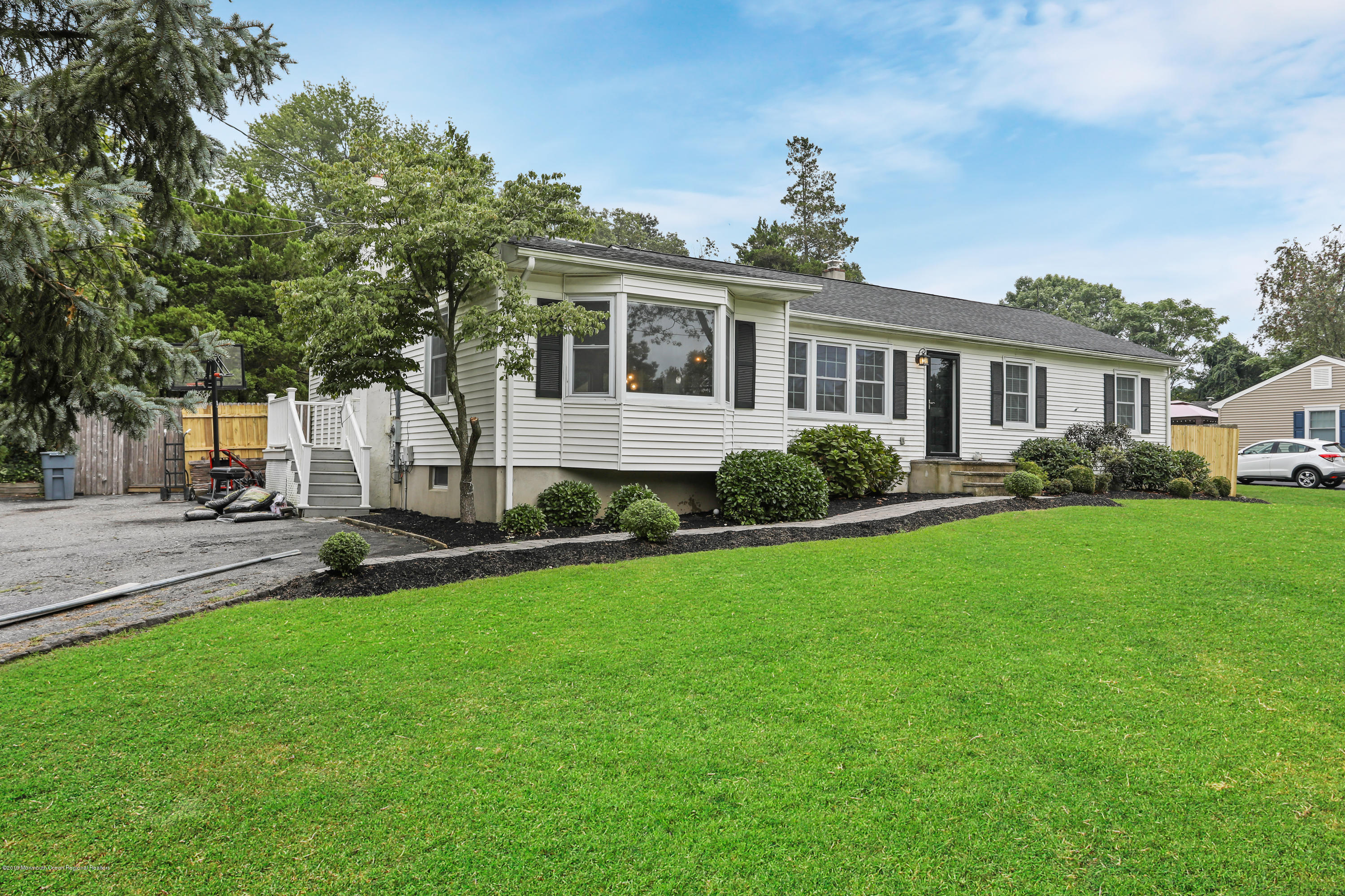 1822 Carmerville Road Wall, NJ 07719 - Photo 2 of 25 a front view of a house with a garden and trees