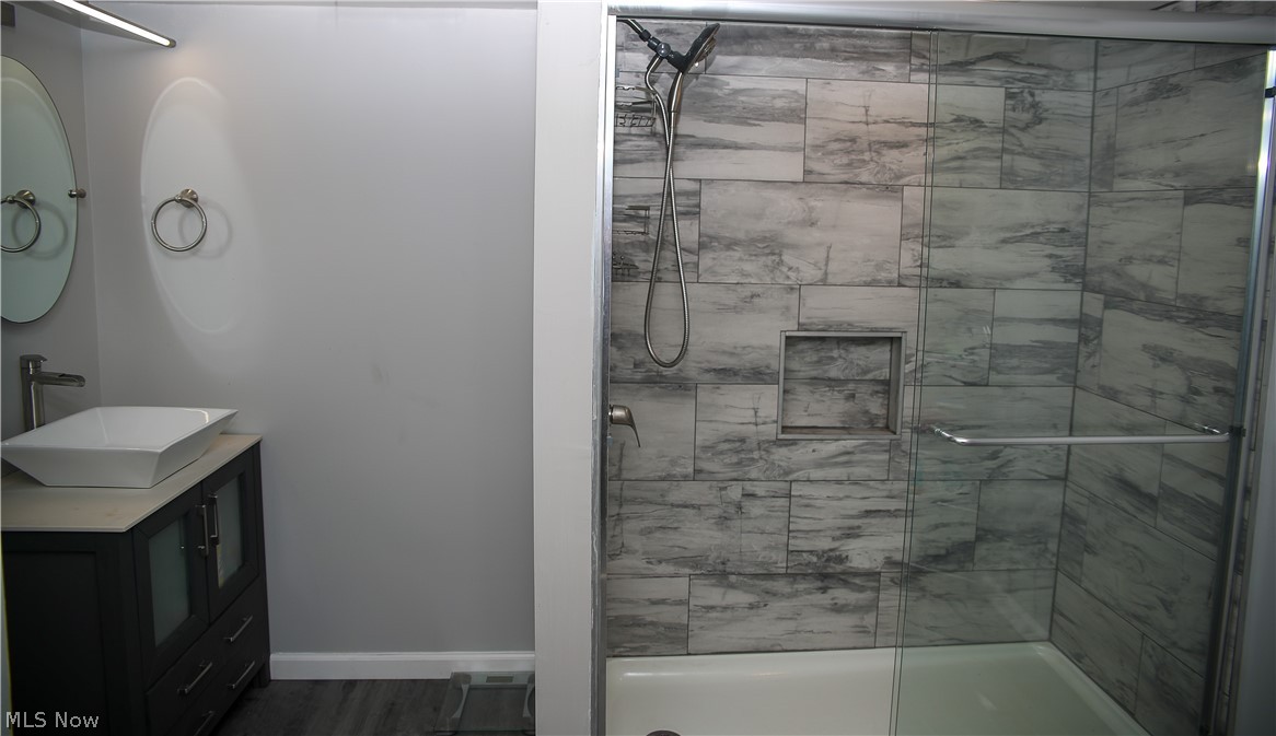 1087 Krumroy Road Akron, OH 44306 - Photo 15 of 23 Modern bathroom featuring a glass-enclosed shower with gray tiled walls and an integrated shower niche