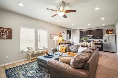 a living room with furniture kitchen view and a large window