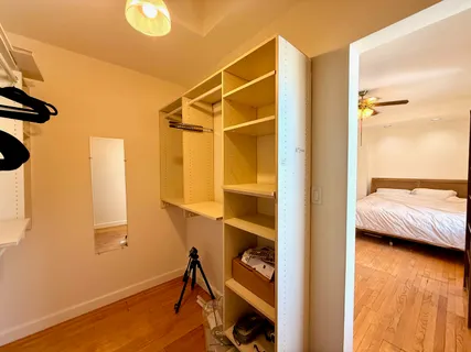 a view of walk in closet with clothes and shoes