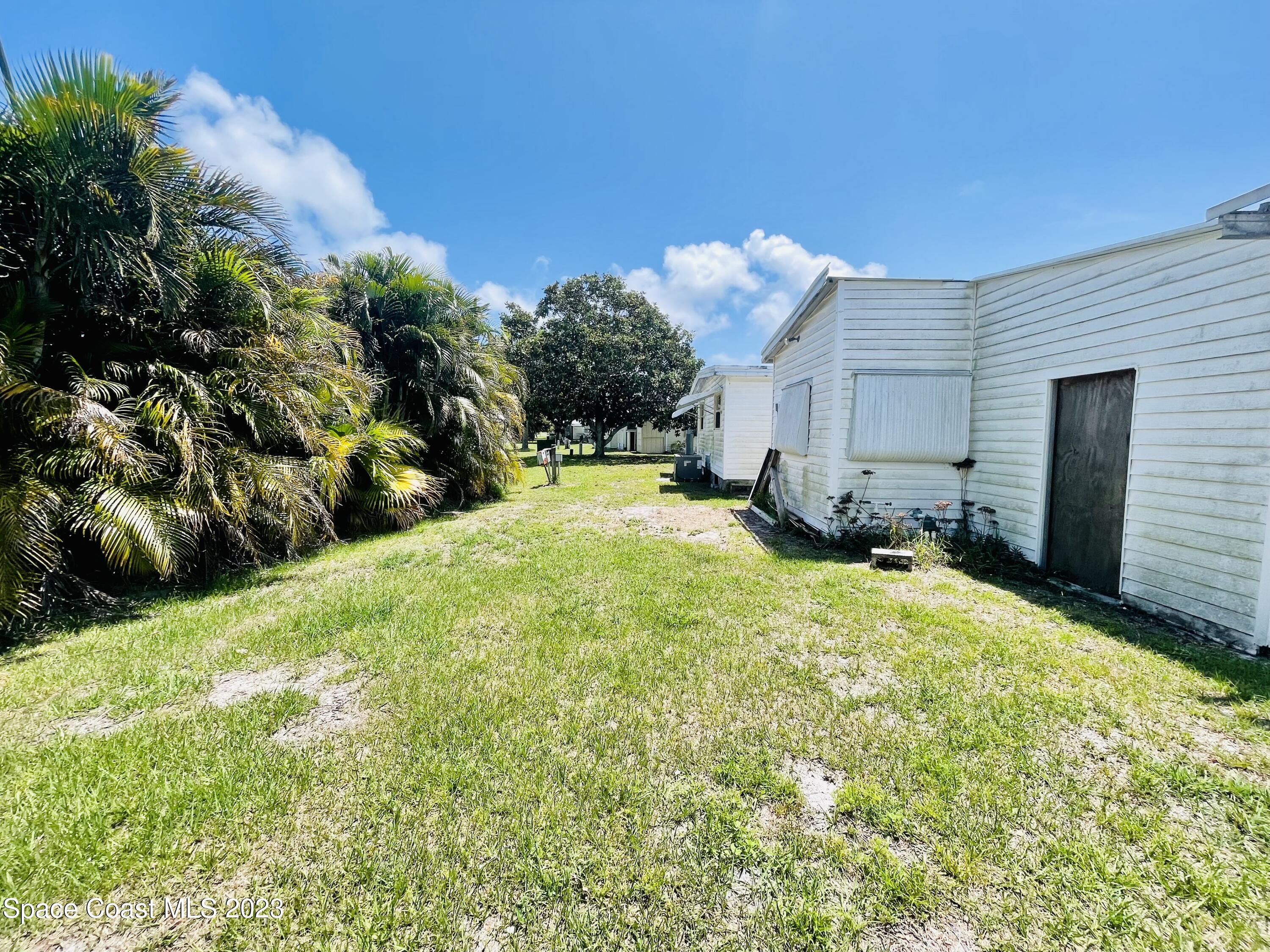 706 Barefoot Boulevard Barefoot Bay, FL 32976 - Photo 14 of 14 a view of a backyard with plants and large trees