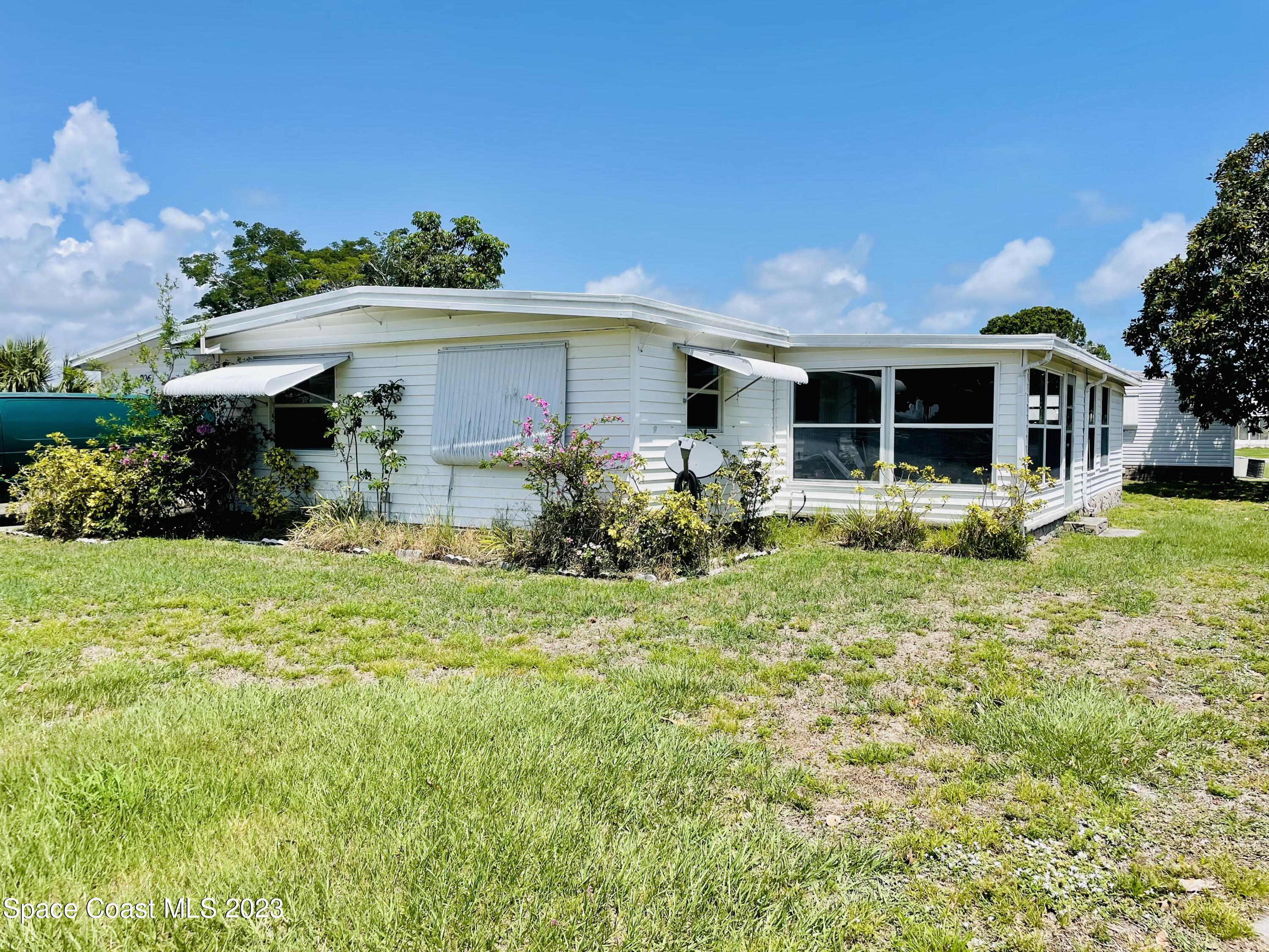 706 Barefoot Boulevard Barefoot Bay, FL 32976 - Photo 4 of 14 a front view of a house with garden