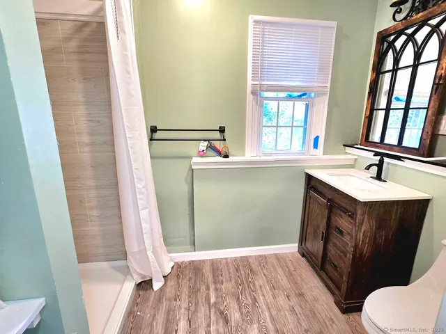 a bathroom with a sink vanity mirror and toilet