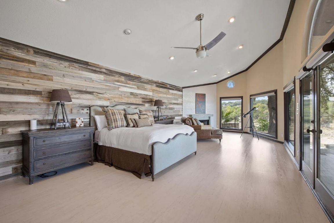 925 Challenger Lakeway, TX 78734 - Photo 19 of 40 a spacious bedroom with a large bed and a chandelier