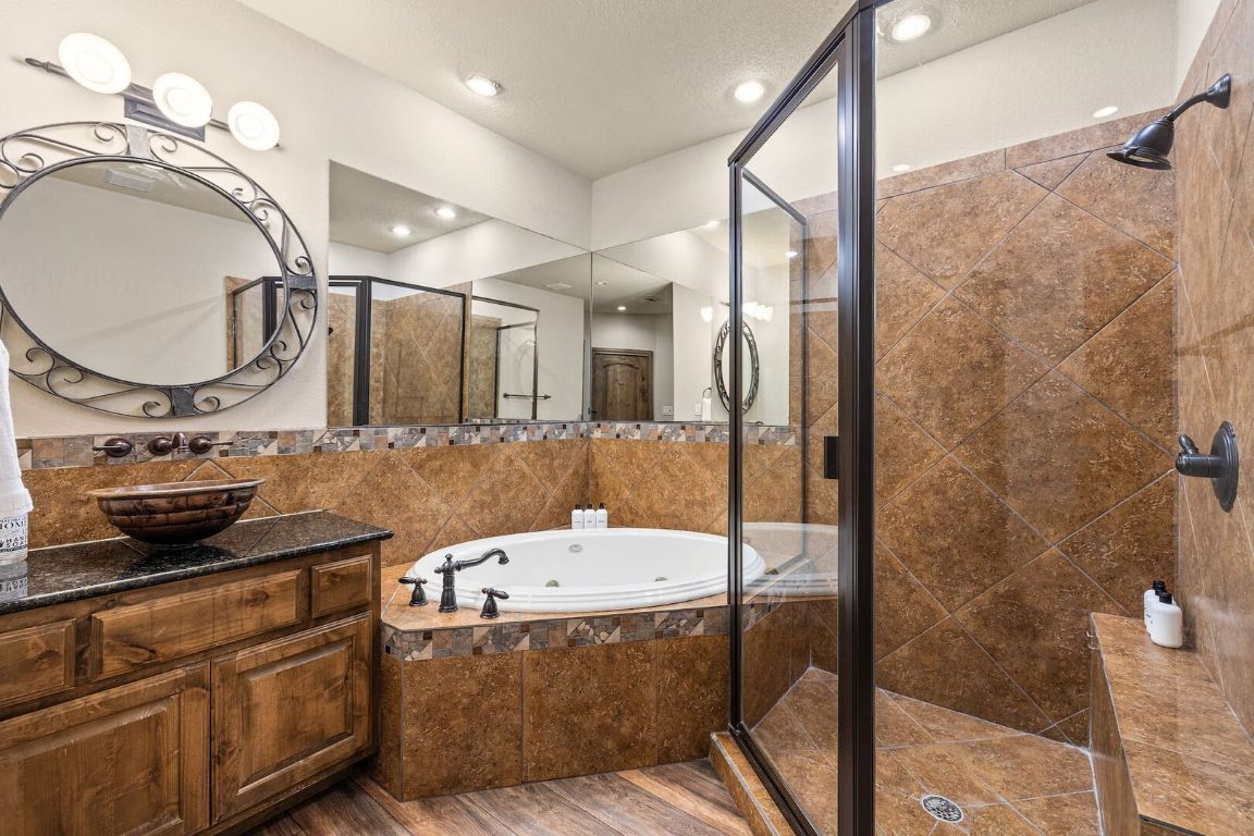 925 Challenger Lakeway, TX 78734 - Photo 26 of 40 a bathroom with a sink a mirror and a shower