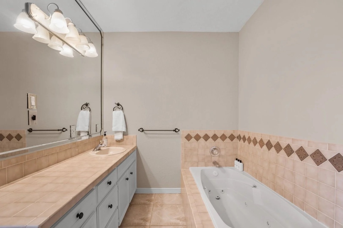 925 Challenger Lakeway, TX 78734 - Photo 29 of 40 a bathroom with a tub sink and mirror