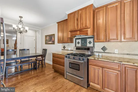 a kitchen with stainless steel appliances granite countertop a stove top oven a sink dishwasher and cabinets with wooden floor