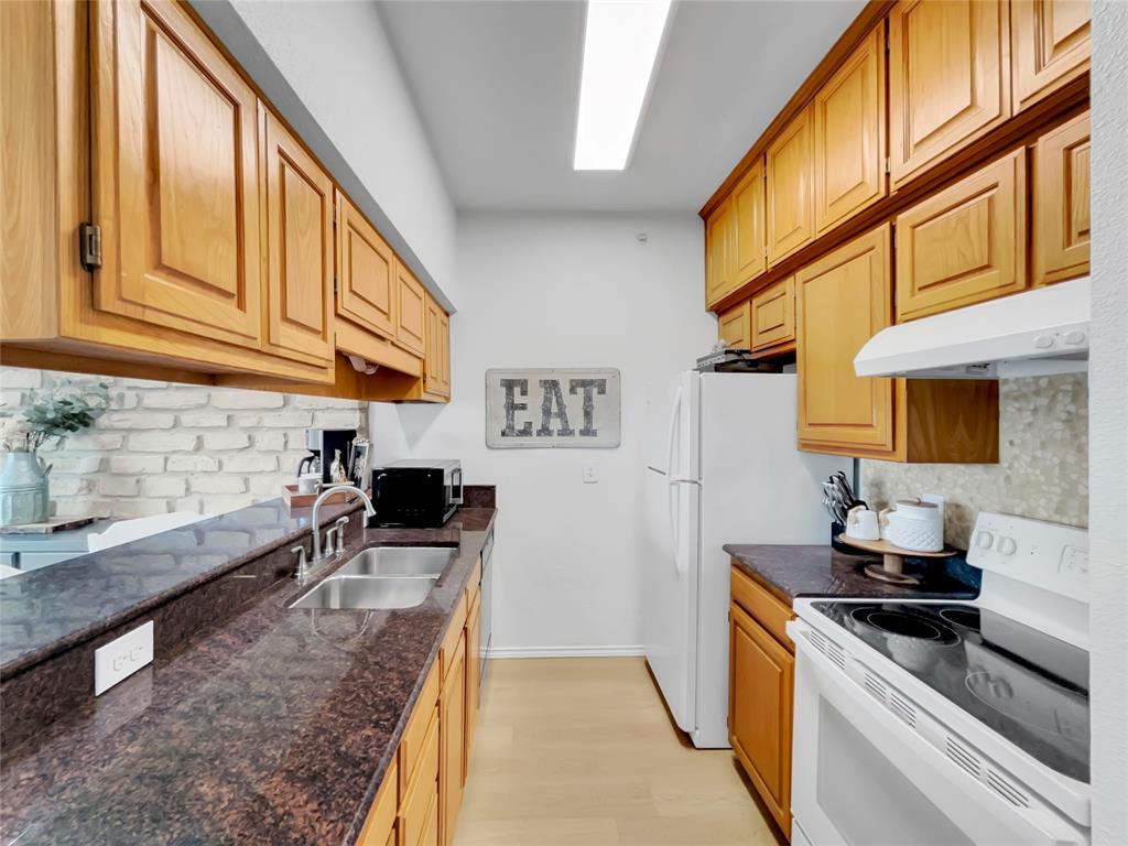 401 East Pearl Street, Unit 2307 Granbury, TX 76048 - Photo 12 of 21 a kitchen with stainless steel appliances granite countertop a stove a sink and a microwave