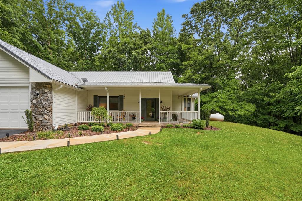 175 Crane Creek Road Young Harris, GA 30582 - Photo 2 of 40 a front view of a house with a garden and trees