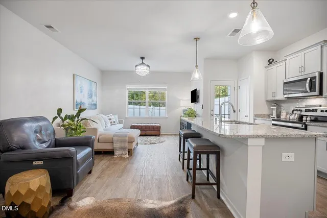 a living room with kitchen island furniture and a wooden floor