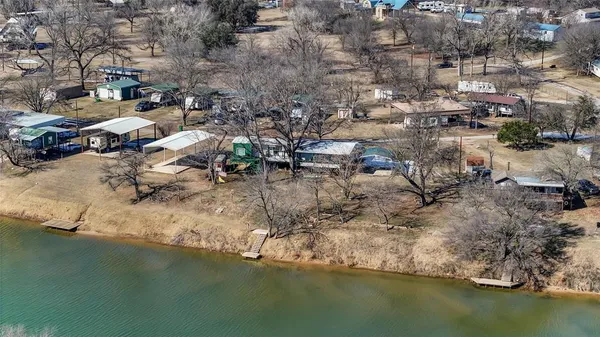 an aerial view of residential houses with outdoor space and lake view