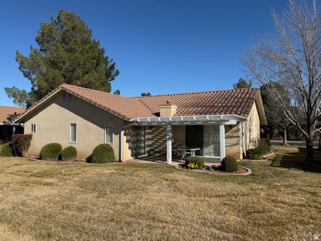1825 West Mathis Park Place, Unit 46 St. George, UT 84770 - Photo 6 of 45 Back of property with a yard, a tile roof, and a chimney