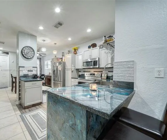 a kitchen with stainless steel appliances granite countertop a sink dishwasher and stove with wooden floor