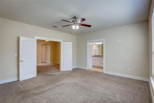 a view of an empty room with a ceiling fan